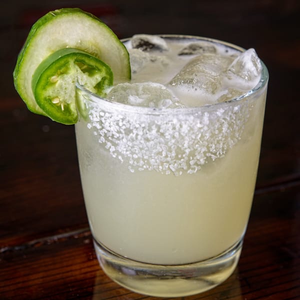 Cuban Burger's spicy margarita with a salted rim, garnished with cucumber and jalapeño slices.