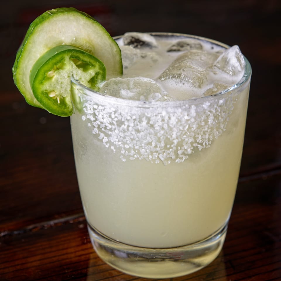Cuban Burger's spicy margarita with a salted rim, garnished with cucumber and jalapeño slices.